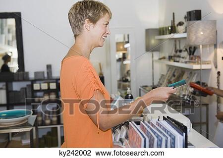 Woman holding a credit card at the checkout counter View Large Photo Image Stock Image - Woman holding a credit card at the checkout counter. Fotosearch