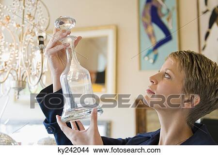 Woman holding a decanter in a store View Large Photo Image Picture - Woman holding a decanter in a store. Fotosearch