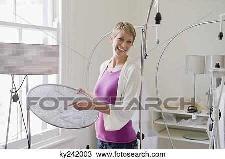 Woman holding a lampshade in a store View Large Photo Image Stock Image - Woman holding a lampshade in a store. Fotosearch