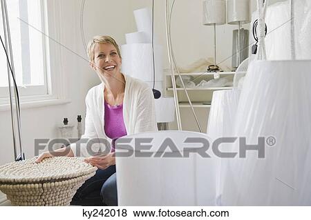 Woman holding a lampshade in a store View Large Photo Image Stock Photo - Woman holding a lampshade in a store. Fotosearch