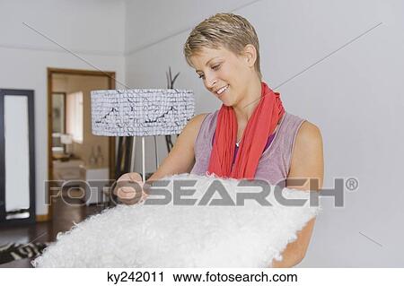 Woman holding a rug in a store View Large Photo Image Stock Image - Woman holding a rug in a store. Fotosearch