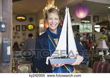 Stock Photography - Woman holding a toy boat in a store. Fotosearch