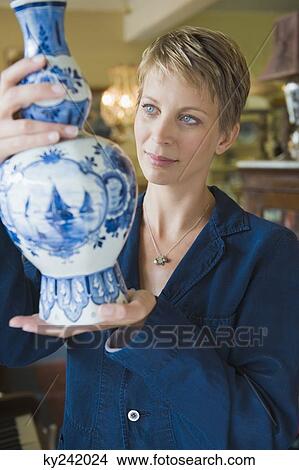 Woman holding a vase in a store View Large Photo Image Picture - Woman holding a vase in a store. Fotosearch