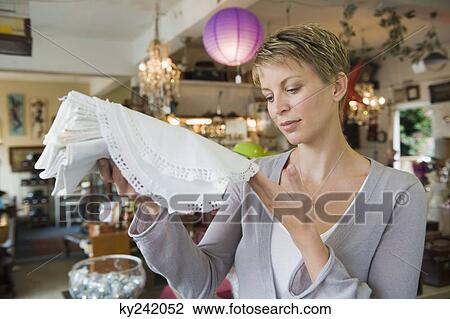 Woman holding tablecloths in a store View Large Photo Image Stock Image - Woman holding tablecloths in a store. Fotosearch