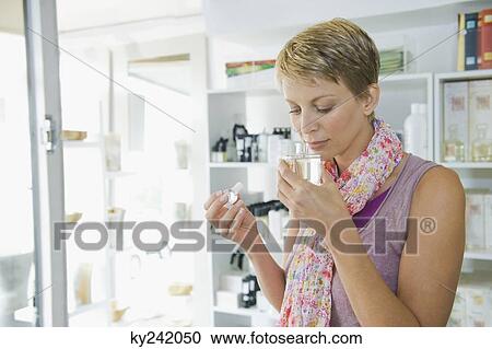 Woman smelling perfume in a store View Large Photo Image Stock Image - Woman smelling perfume in a store. Fotosearch