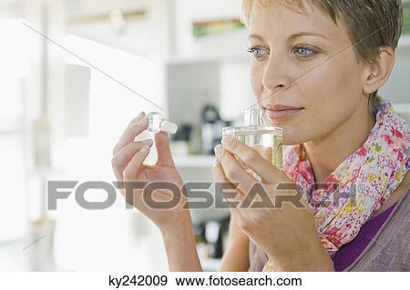 Woman smelling perfume in a store View Large Photo Image Stock Photo - Woman smelling perfume in a store. Fotosearch