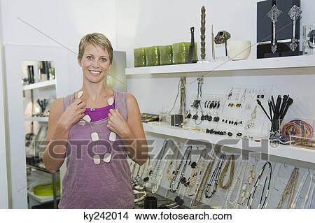 Woman wearing a necklace in a jewelry store View Large Photo Image Picture - Woman wearing a necklace in a jewelry store. Fotosearch