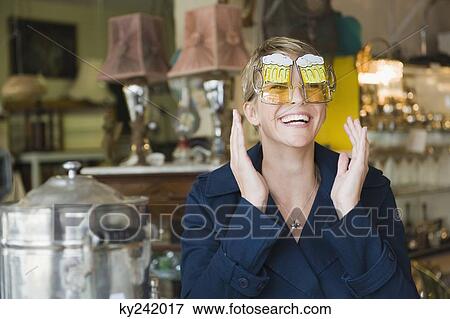 Woman wearing sunglasses in a store View Large Photo Image Stock Photo - Woman wearing sunglasses in a store. Fotosearch
