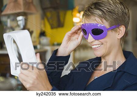 Stock Photography - Woman wearing sunglasses in a store. Fotosearch