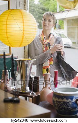 Woman window shopping in a store View Large Photo Image Stock Photograph - Woman window shopping in a store. Fotosearch