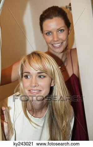 Two women having fun in a boutique View Large Photo Image Stock Image - Two women having fun in a boutique. Fotosearch