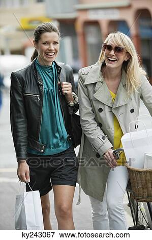 Two women walking with shopping bags View Large Photo Image Stock Photo - Two women walking with shopping bags. Fotosearch