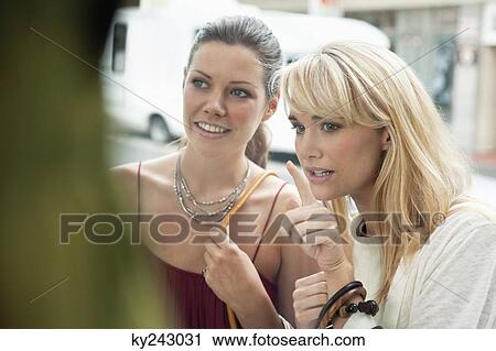 Two women window shopping in a boutique View Large Photo Image Stock Image - Two women window shopping in a boutique. Fotosearch