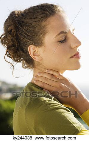 Close-up of a woman rubbing her neck View Large Photo Image Stock Photo - Close-up of a woman rubbing her neck. Fotosearch