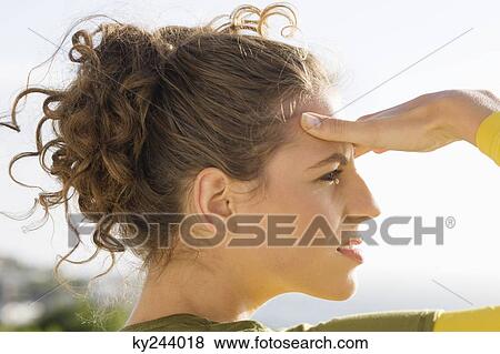 Stock Photo - Close-up of a woman shielding eyes. Fotosearch