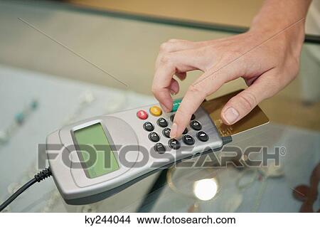 Customer using credit card reader in a boutique View Large Photo Image Picture - Customer using credit card reader in a boutique. Fotosearch