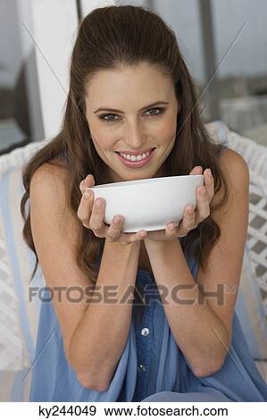 Portrait of a woman holding a bowl View Large Photo Image Stock Photo - Portrait of a woman holding a bowl. Fotosearch