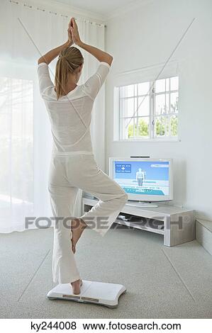 Woman doing yoga in front of television View Large Photo Image Stock Photo - Woman doing yoga in front of television. Fotosearch