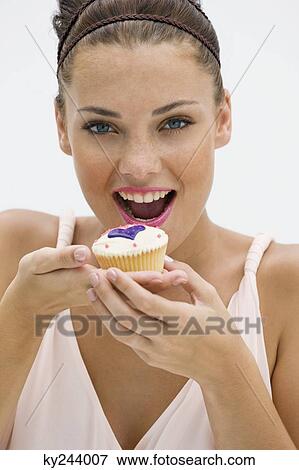 Woman eating a cupcake View Large Photo Image Stock Photo - Woman eating a cupcake. Fotosearch