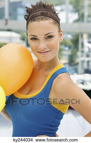 Woman holding balloons and smiling View Large Photo Image Picture - Woman holding balloons and smiling. Fotosearch