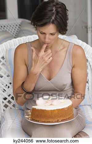 Stock Photograph - Woman tasting a cake. Fotosearch