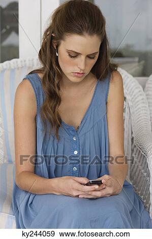 Woman text messaging on a mobile phone View Large Photo Image Stock Photo - Woman text messaging on a mobile phone. Fotosearch