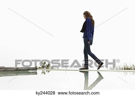 Stock Photo - Woman walking at the poolside. Fotosearch