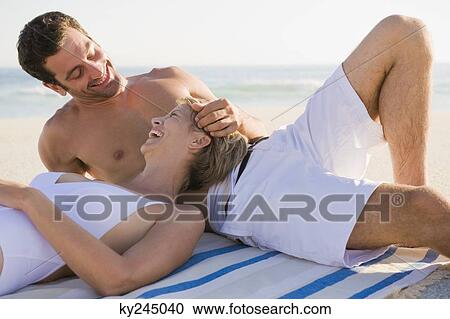 Couple lying on the beach View Large Photo Image Stock Image - Couple lying on the beach. Fotosearch