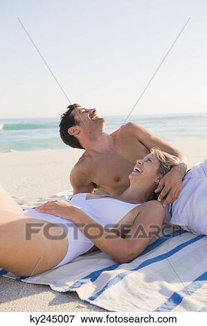 Couple lying on the beach View Large Photo Image Stock Photo - Couple lying on the beach. Fotosearch