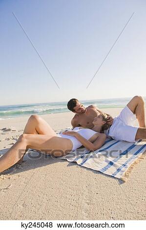 Couple lying on the beach View Large Photo Image Stock Photo - Couple lying on the beach. Fotosearch