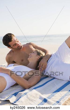 Couple lying on the beach View Large Photo Image Stock Photograph - Couple lying on the beach. Fotosearch