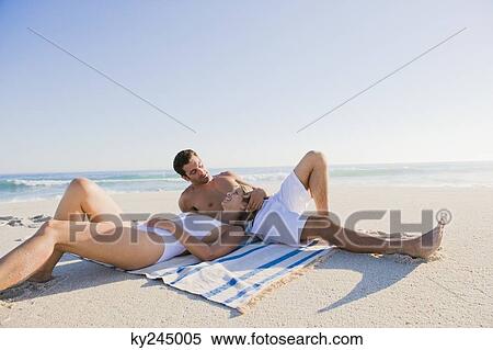 Couple lying on the beach View Large Photo Image Stock Photography - Couple lying on the beach. Fotosearch