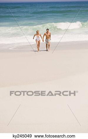 Stock Photo - Couple running on the beach. Fotosearch