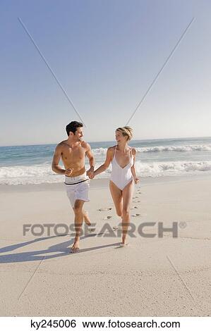Stock Photograph - Couple running on the beach. Fotosearch