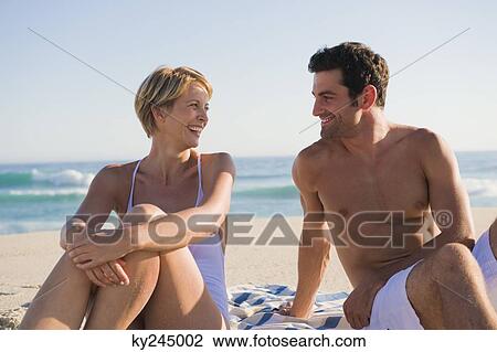 Couple sitting on the beach View Large Photo Image Stock Image - Couple sitting on the beach. Fotosearch