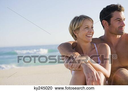Couple sitting on the beach View Large Photo Image Stock Image - Couple sitting on the beach. Fotosearch