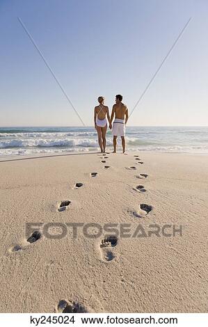 Couple standing on the beach View Large Photo Image Picture - Couple standing on the beach. Fotosearch