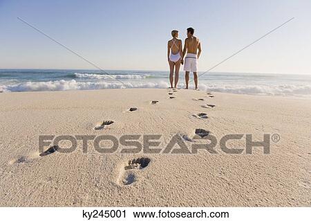 Couple standing on the beach View Large Photo Image Stock Image - Couple standing on the beach. Fotosearch