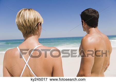 Couple standing on the beach View Large Photo Image Stock Photo - Couple standing on the beach. Fotosearch
