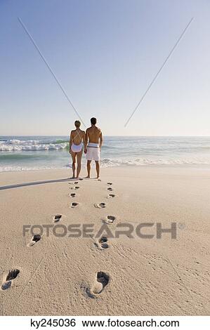 Stock Photograph - Couple standing on the beach. Fotosearch