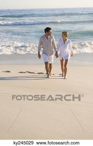 Couple walking on the beach View Large Photo Image Stock Photo - Couple walking on the beach. Fotosearch