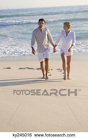 Couple walking on the beach View Large Photo Image Stock Photograph - Couple walking on the beach. Fotosearch