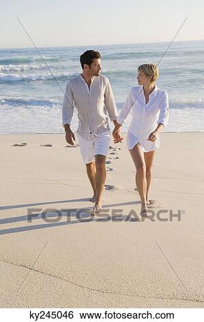 Couple walking on the beach View Large Photo Image Stock Photograph - Couple walking on the beach. Fotosearch