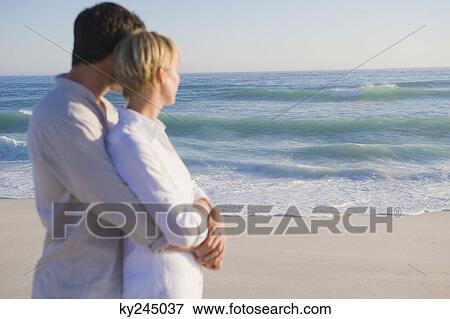 Man embracing a woman from behind View Large Photo Image Stock Photo - Man embracing a woman from behind. Fotosearch