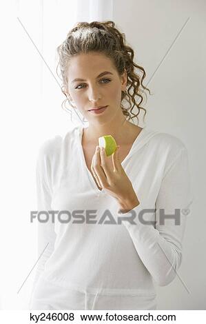 Close-up of a woman eating fruit View Large Photo Image Stock Photo - Close-up of a woman eating fruit. Fotosearch