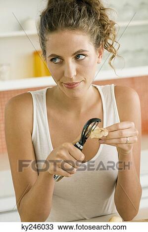 Close-up of a woman peeling potatoes View Large Photo Image Stock Image - Close-up of a woman peeling potatoes. Fotosearch