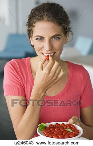 Portrait of a woman eating plum tomatoes View Large Photo Image Stock Image - Portrait of a woman eating plum tomatoes. Fotosearch
