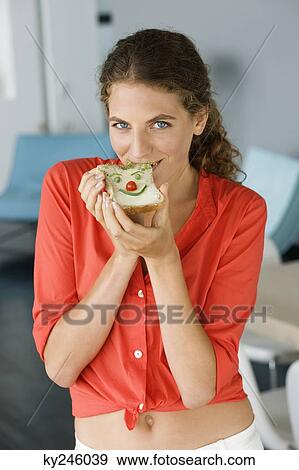 Stock Photo - Portrait of a woman eating sandwich. Fotosearch