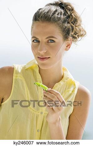 Portrait of a woman holding a pea pod View Large Photo Image Stock Photo - Portrait of a woman holding a pea pod. Fotosearch