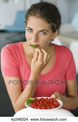 Portrait of a woman holding plum tomatoes on a plate View Large Photo Image Picture - Portrait of a woman holding plum tomatoes on a plate. Fotosearch
